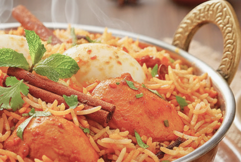 Steaming chicken biryani with basmati rice and spices