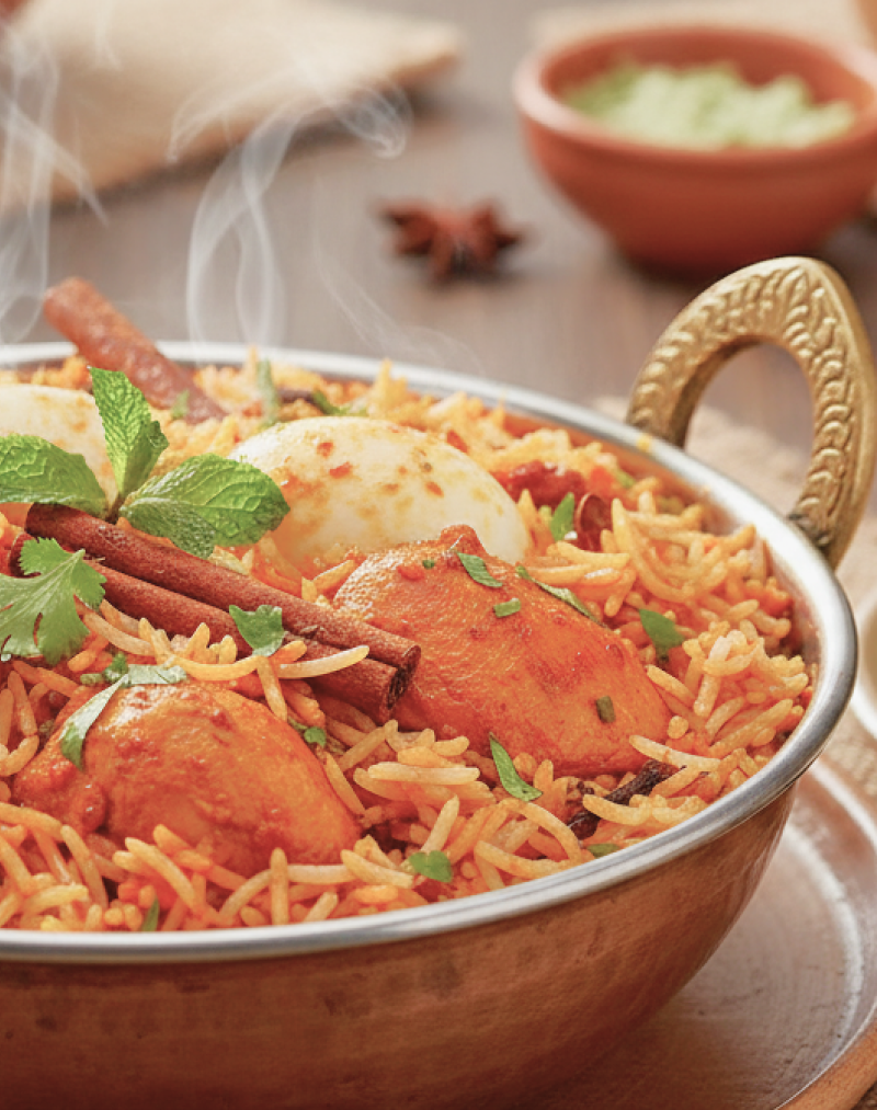Steaming chicken biryani with basmati rice and spices