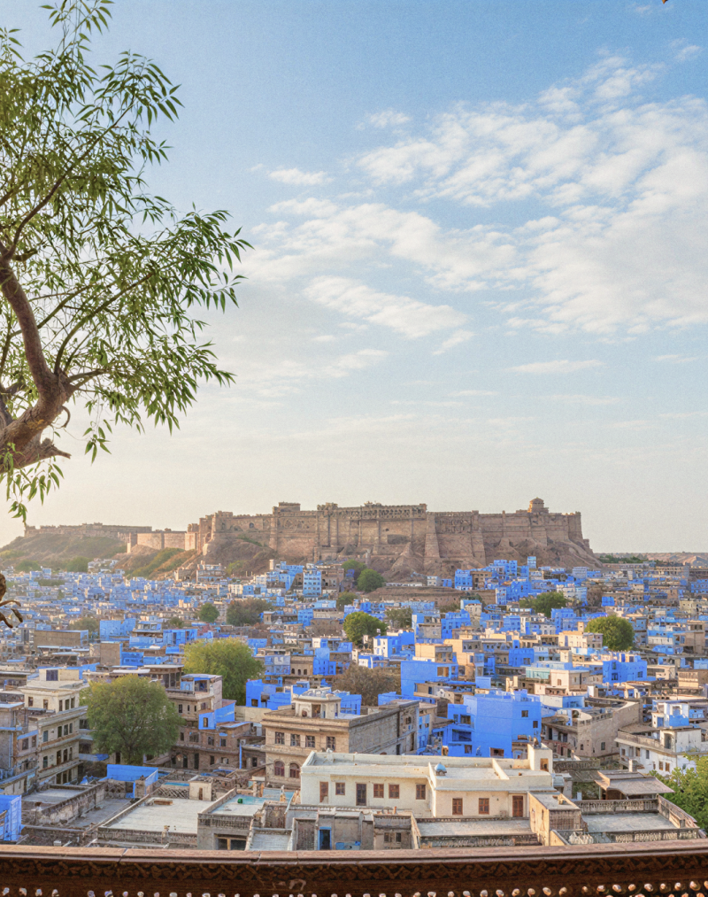 Panoramic view of Jodhpur's blue city and Mehrangarh Fort framed by carved Rajasthani arches — a glimpse into the heart of religious places in Jodhpur. thumbnail