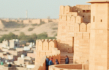 Visitors walking along the ramparts of Jaisalmer Fort, one of the most iconic historical places in India for tourists, overlooking the golden city below thumbnail