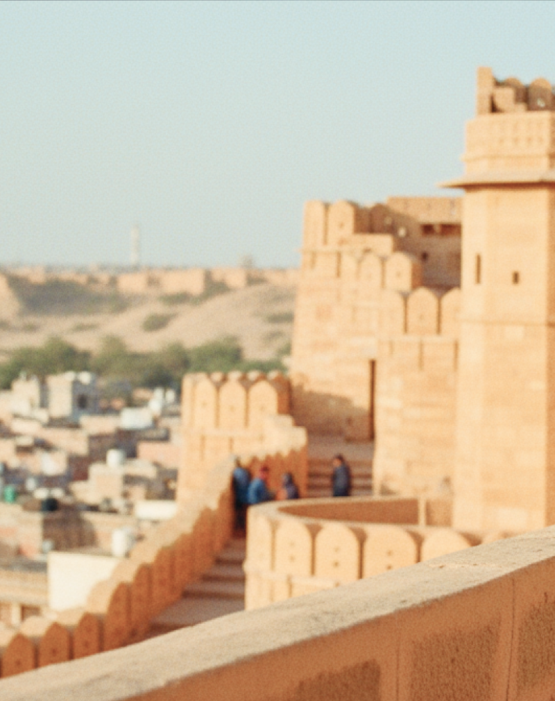 Visitors walking along the ramparts of Jaisalmer Fort, one of the most iconic historical places in India for tourists, overlooking the golden city below thumbnail