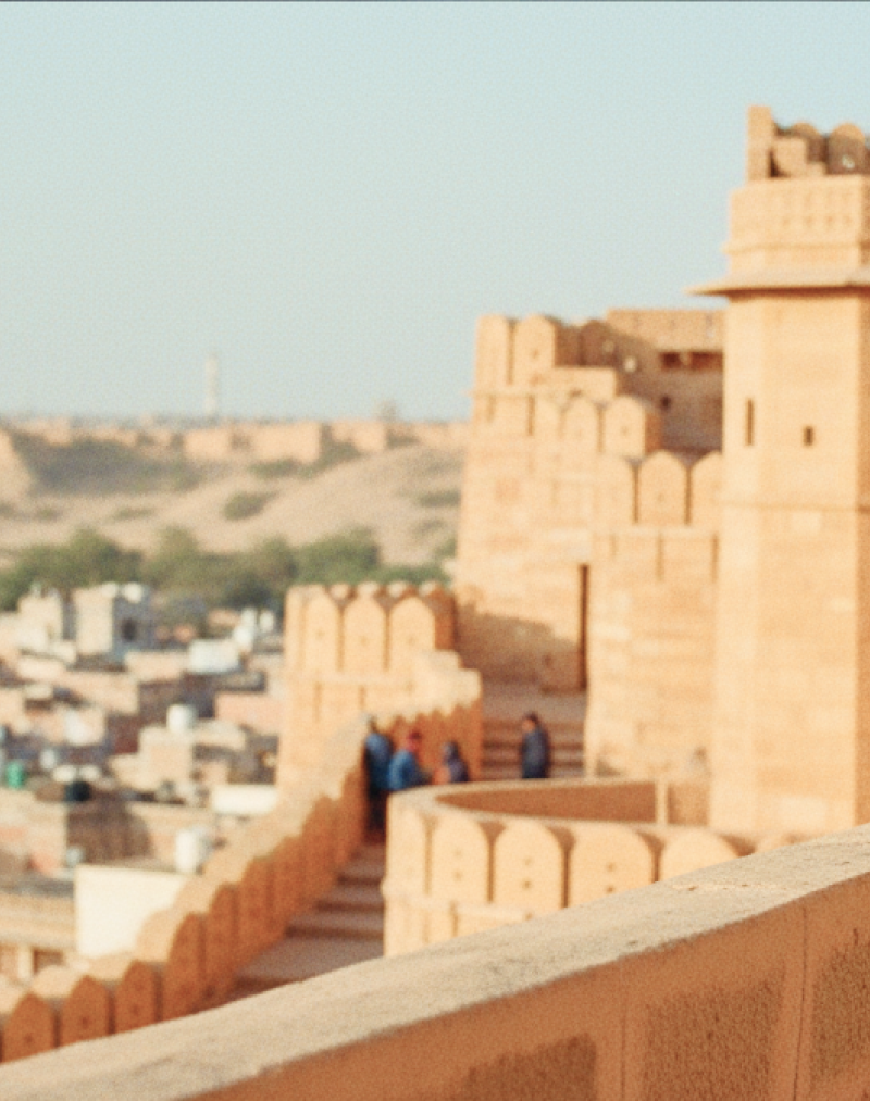 Visitors walking along the ramparts of Jaisalmer Fort, one of the most iconic historical places in India for tourists, overlooking the golden city below thumbnail