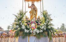 A festive Easter in Kerala procession featuring a floral float with a Jesus statue, devotees in white attire, and colourful ceremonial umbrellas thumbnail