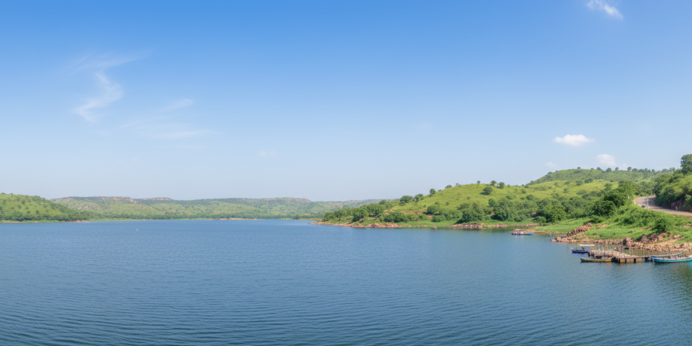 A calm blue lake surrounded by green hills with small boats docked near the shore, a scenic stop on a day Pune itinerary