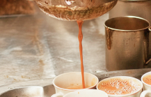 Traditional Kolkata chai being strained into cups at a tea stall