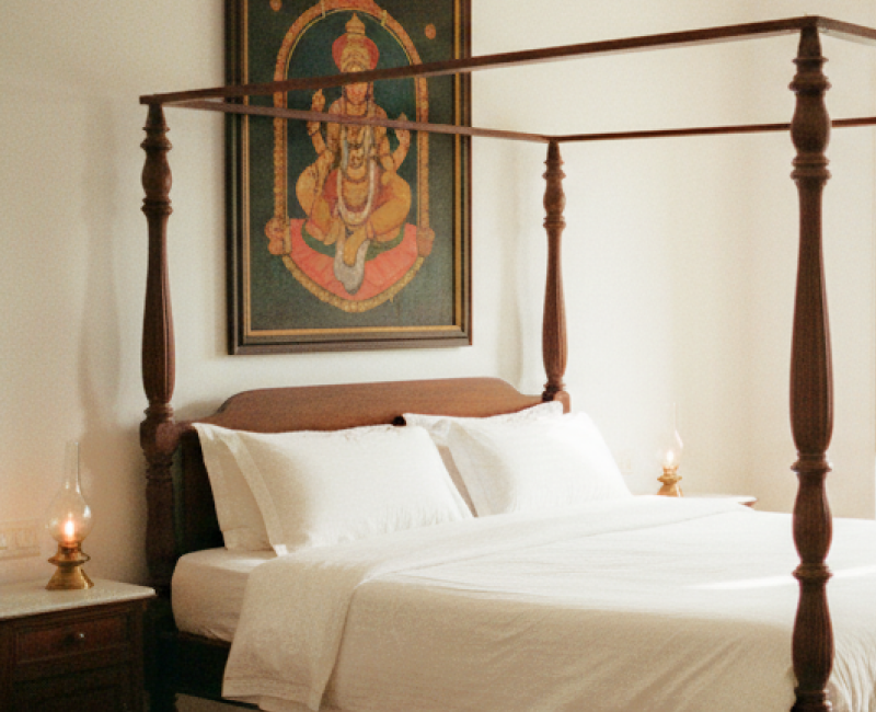 Charming stay in Pondicherry — a colonial four poster bedroom with white linen, Athangudi tiled floors, brass oil lamps, and a Tanjore painting above the bed thumbnail