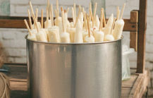 Pandit Kulfi stall in Jaipur with a metal pot filled with traditional kulfi ice cream sticks on a wooden street cart thumbnail