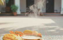 Pondicherry hotels and homestays experience — a colonial courtyard breakfast with steaming filter coffee, fresh tropical fruit, and a croissant on Athangudi tiled table thumbnail