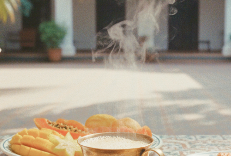Pondicherry hotels and homestays experience — a colonial courtyard breakfast with steaming filter coffee, fresh tropical fruit, and a croissant on Athangudi tiled table thumbnail