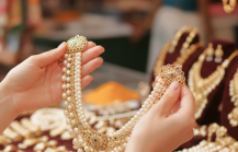 woman holding up pearl and gold necklace thumbnail