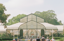 day Bangalore itinerary stop at Lalbagh Botanical Garden — visitors walking toward the iconic Glass House surrounded by century old trees and rose beds thumbnail