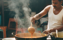 A Tamil street food vendor ladles curry at a Pondicherry market stall — the kind of spot you'll find when exploring where to eat in Pondicherry beyond the café strip thumbnail