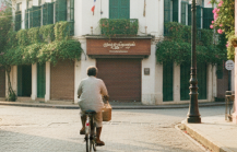 A cyclist rides through an empty cobblestone street in Pondicherry's White Town at golden hour, flanked by colonial buildings and bougainvillea — captured in this Pondicherry travel guide thumbnail