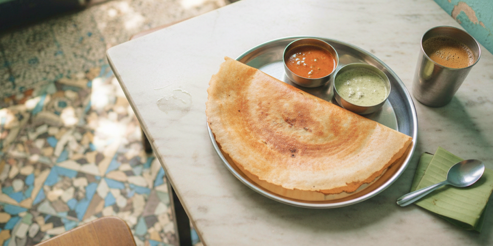 A masala dosa served in a steel thali with sambar and coconut chutney at a traditional Chennai tiffin shop, where to eat in Chennai for an authentic South Indian breakfast
