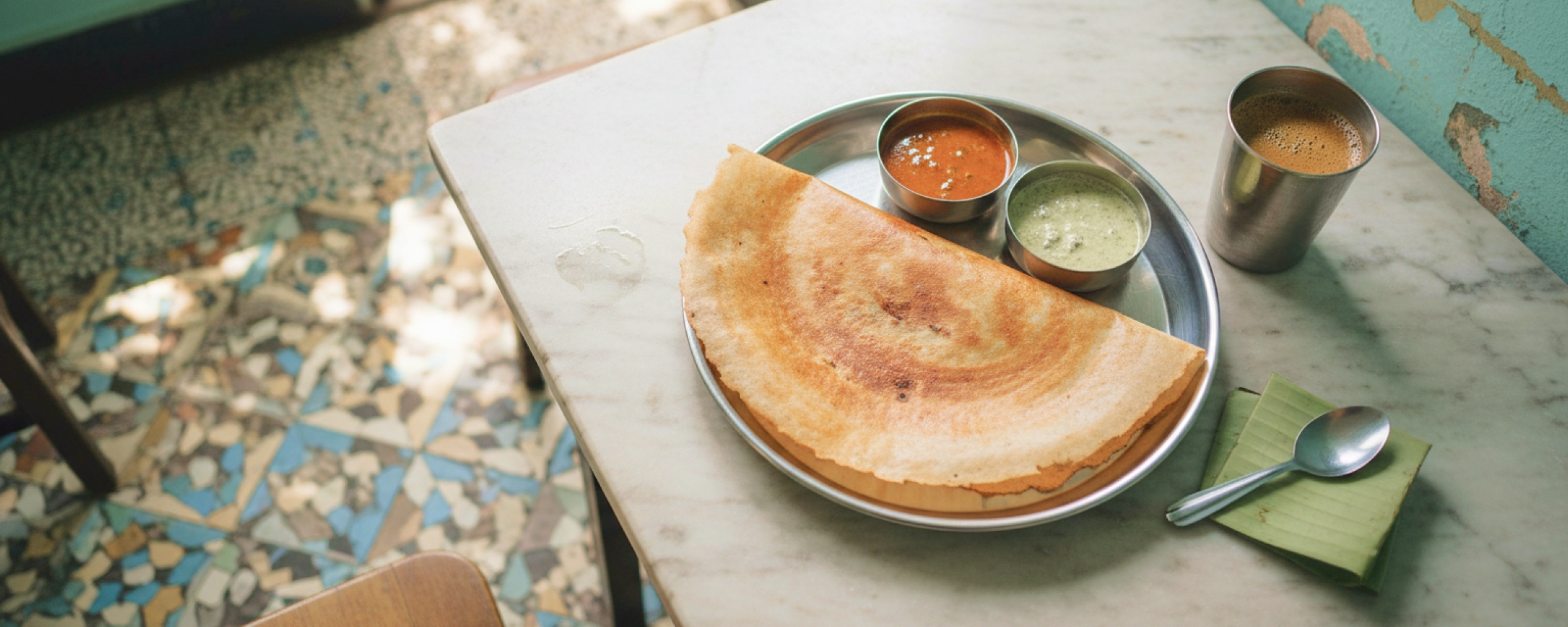 A masala dosa served in a steel thali with sambar and coconut chutney at a traditional Chennai tiffin shop, where to eat in Chennai for an authentic South Indian breakfast