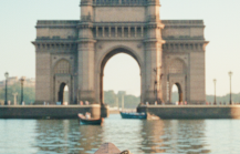 Boat's eye view of the Gateway of India and Taj Mahal Palace on the Mumbai travel guide, harbour glowing in early morning light thumbnail