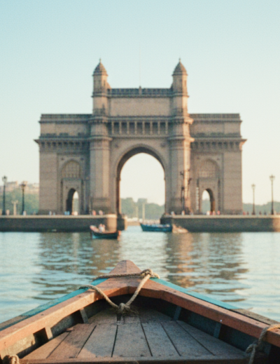 Boat's eye view of the Gateway of India and Taj Mahal Palace on the Mumbai travel guide, harbour glowing in early morning light thumbnail