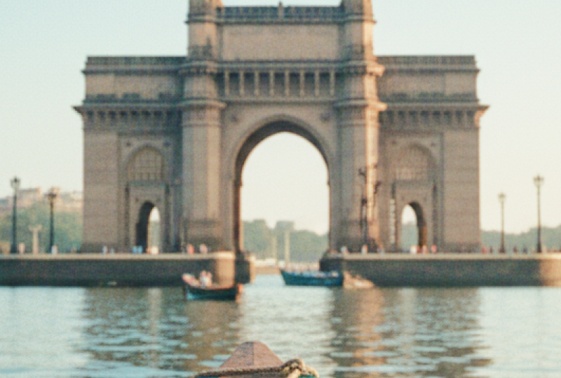 Boat's eye view of the Gateway of India and Taj Mahal Palace on the Mumbai travel guide, harbour glowing in early morning light thumbnail