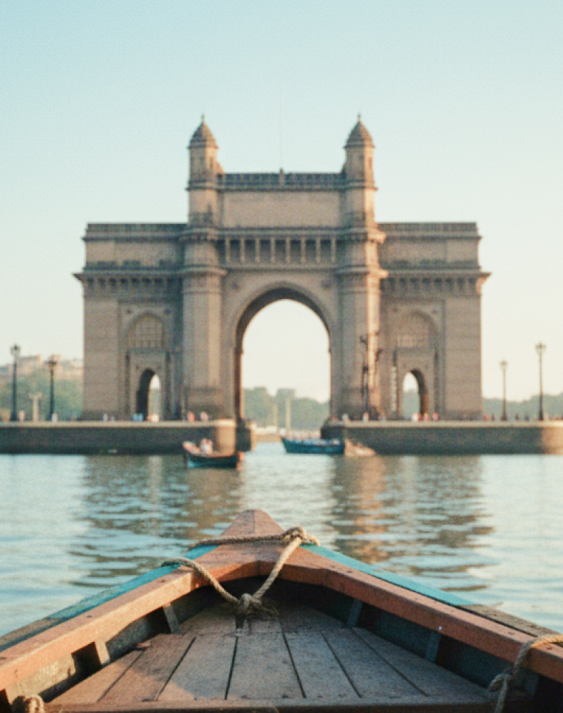 Boat's eye view of the Gateway of India and Taj Mahal Palace on the Mumbai travel guide, harbour glowing in early morning light thumbnail