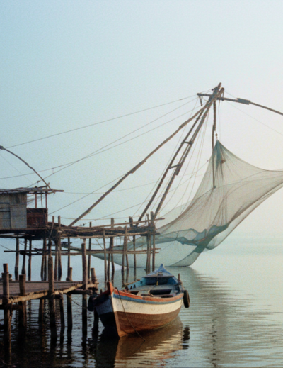 Chinese fishing nets and a weathered wooden boat on the misty Fort Kochi waterfront at dawn — a highlight of any day Kochi itinerary thumbnail