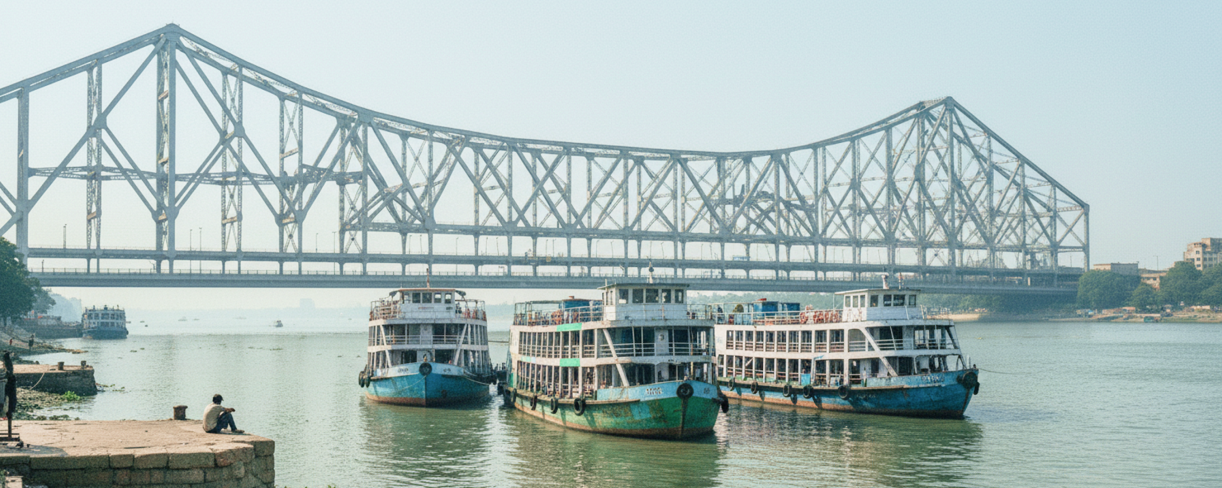 Passenger ferries moored on the Hooghly River with Howrah Bridge in the background, Kolkata travel guide