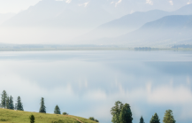 Panoramic view of a serene alpine lake surrounded by snow capped mountains and green meadows — Kashmir travel guide thumbnail
